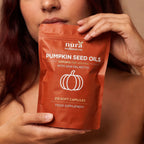 Woman holding the Nura Pumpkin Seed Oils pouch, 3,000mg per serving with saw palmetto, 210 soft capsules