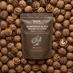 Front of the Nura Wormwood, Black Walnut & Clove pouch, 210 capsules, 500mg per serving, beside walnuts and loose capsules